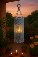 Macrame hanging light fixture in a garden setting with sunset in the background