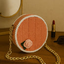 Side view of handmade round macrame bag showing structured shape and gold chain detail
