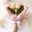 Knitted tulip bouquet with pink ribbon on a white background