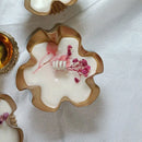 Decorative ceramic bowls with floral elements on a white fabric background