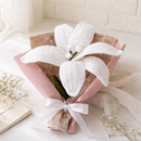 White knitted flower on a pink cushion with a white background